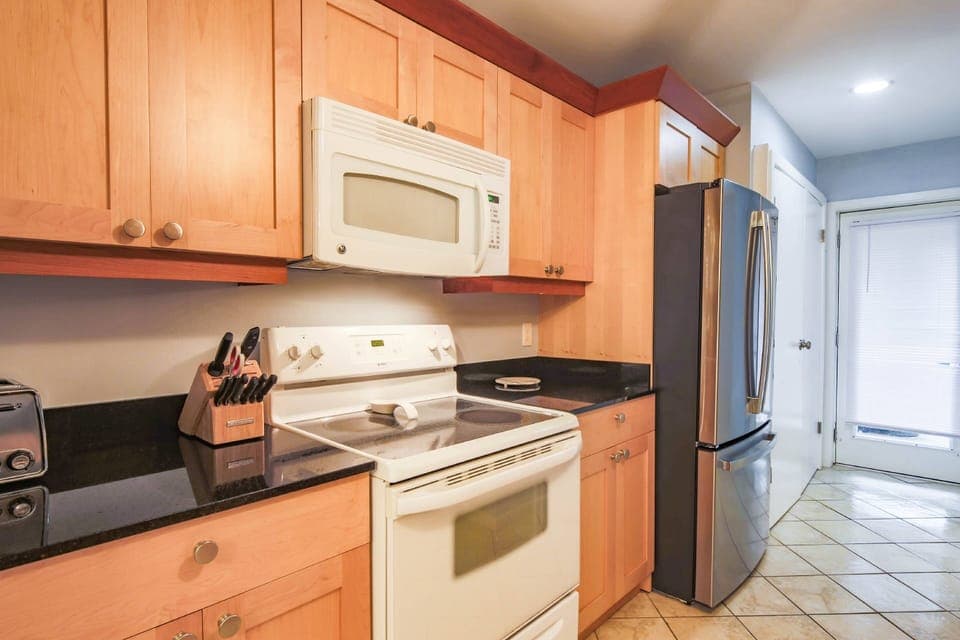 The kitchen features a refrigerator, range, microwave, toaster and more.