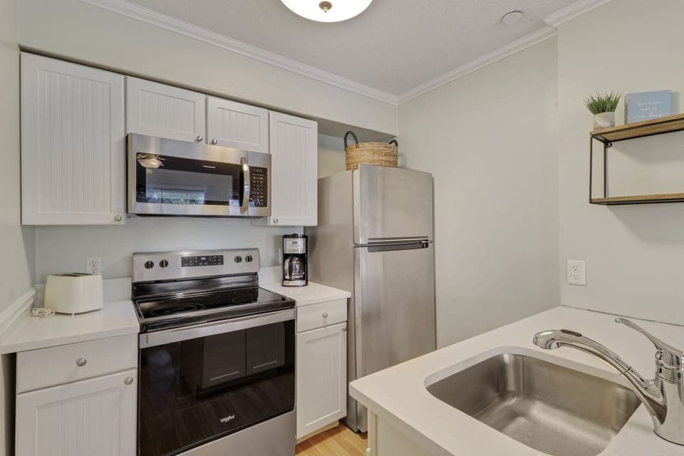 Kitchen - New appliances and countertops in this bright, white kitchen.  Standard coffeemaker.