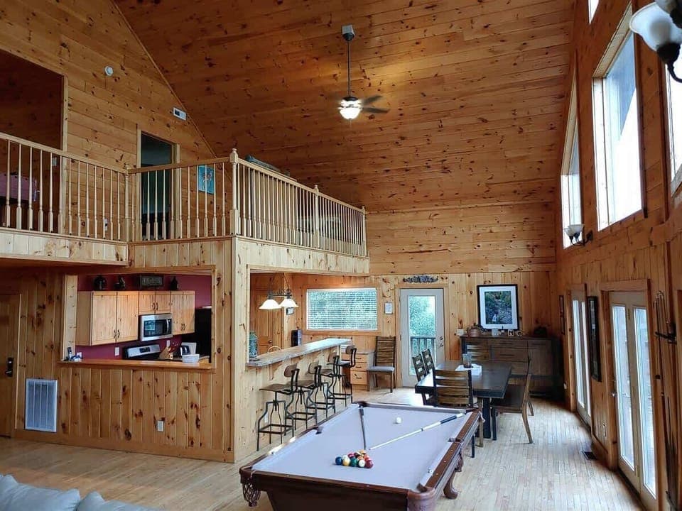 The great room has a pool table and dining area with extra seating at the bar.