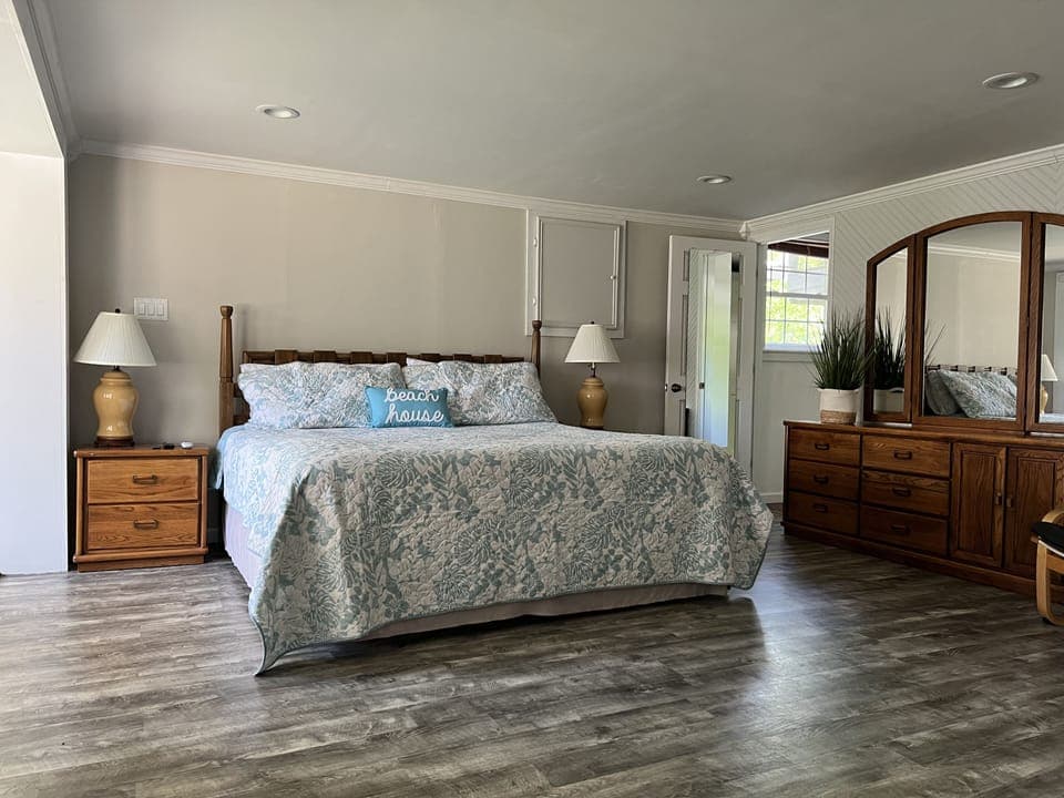 Large king size bed in the master with a dresser and walk-in closet.
