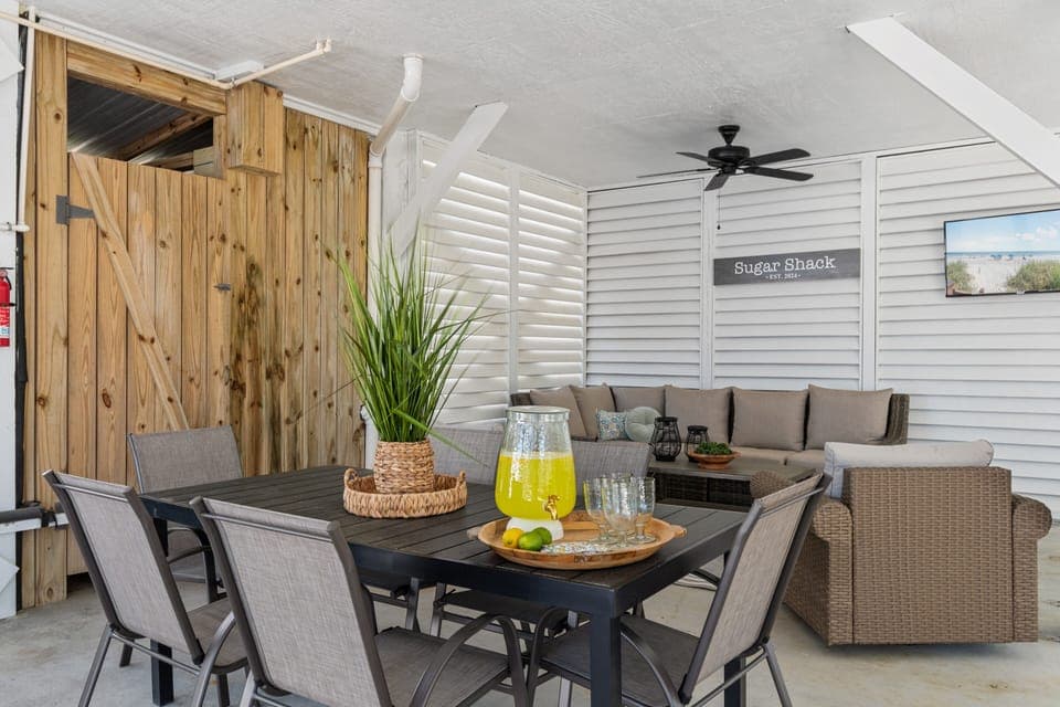 Enjoy refreshing drinks and meals in your covered outdoor dining area, complete with comfortable seating and coastal charm.