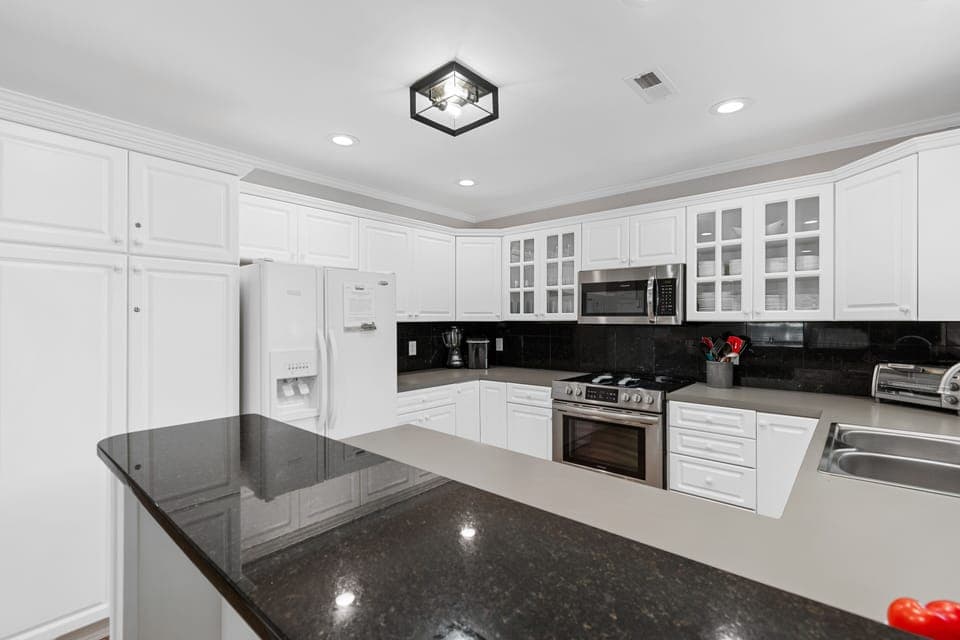 Your gourmet kitchen awaits with gleaming granite counters, premium stainless appliances, and crisp white cabinetry - perfect for creating memorable meals together.