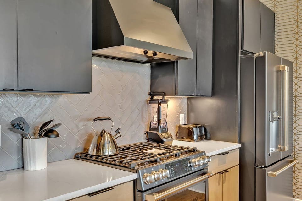 Modern sleek kitchen stocked with your basic cooking essentials. Complete with stainless steel appliances and breakfast bar seating.