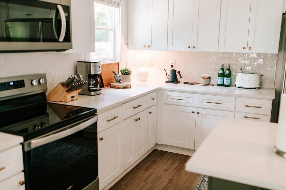 The luxurious kitchen is complete with stainless steel appliances and an island with seating for three, perfect for socializing with friends and family while creating delicious meals. 
