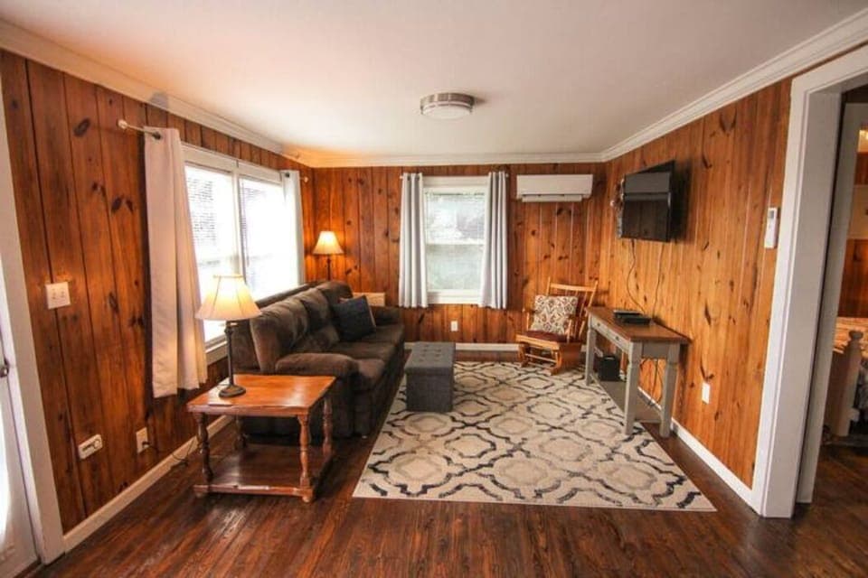 Living room with smart TV, board games stored in ottoman.