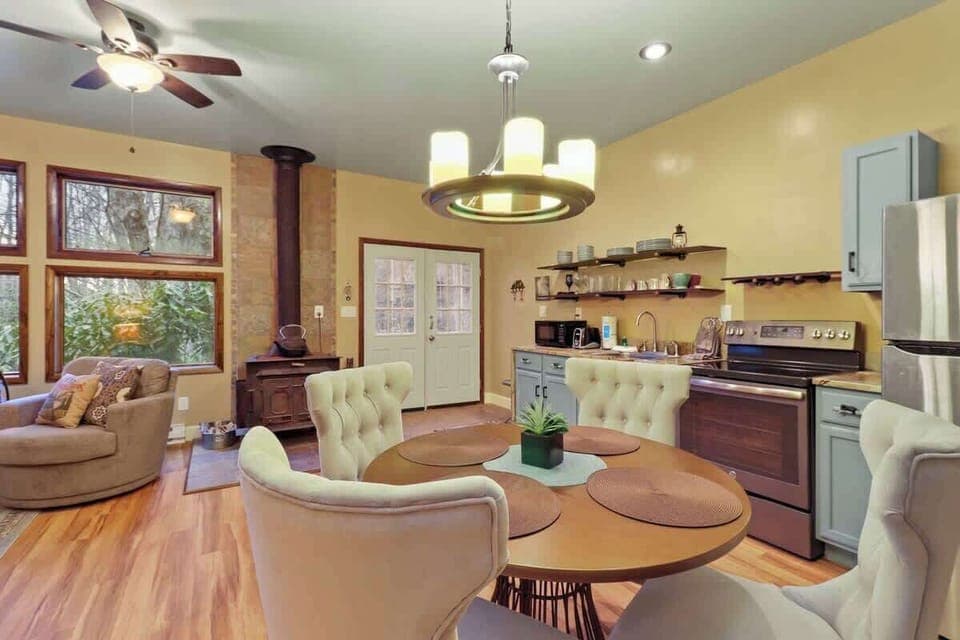 Seamless integration: A dining space nestled between the kitchen and living area, bridging the gap with the warmth of a central fireplace.
