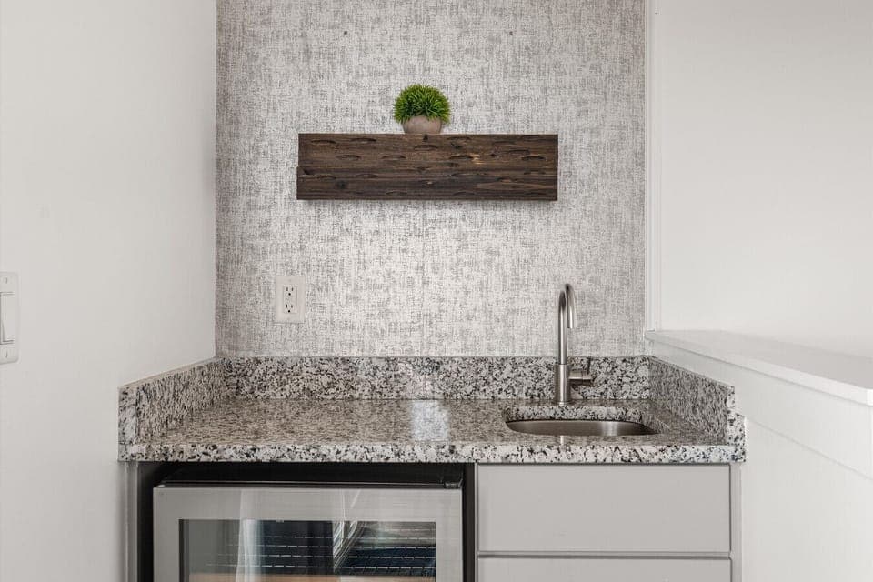 The wet bar on the third level — a mini fridge, and a sink.