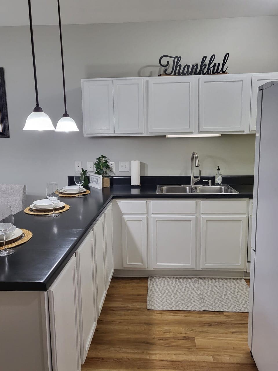 View into kitchen with bar and dining area on left