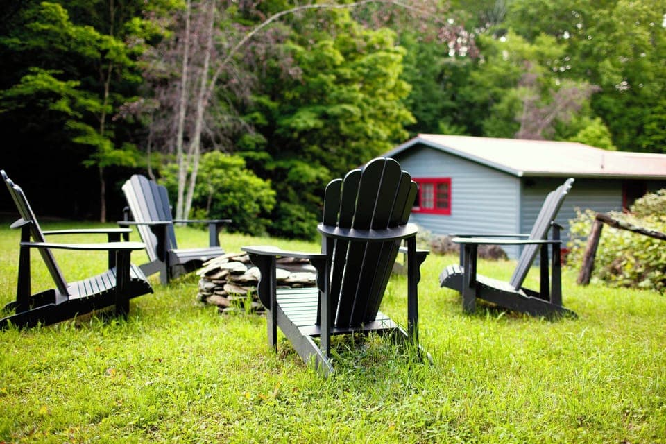 Adirondack chairs surrounding a fire pit to sit and relax in.