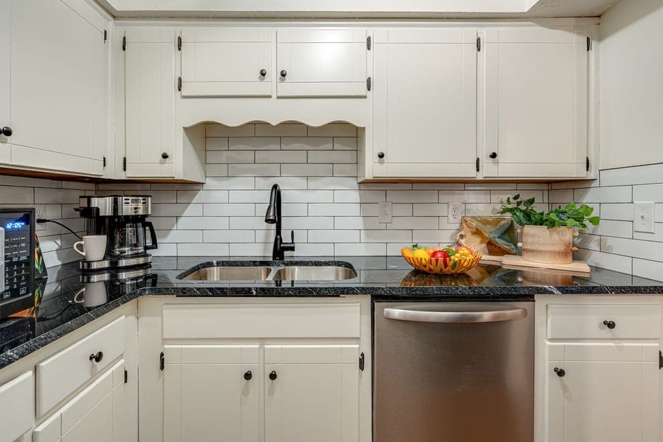 Full kitchen stocked with basic cooking essentials and stainless steel appliances.