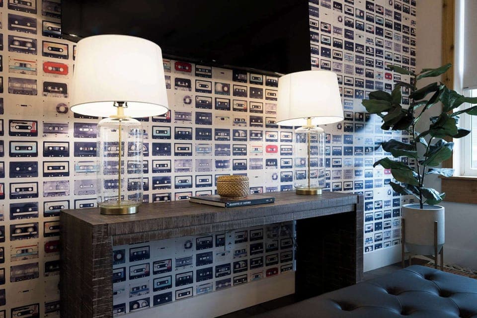 Immerse yourself in a blast from the past with a living room featuring a stunning display of cassette tapes on the wall, perfect for any audiophile.