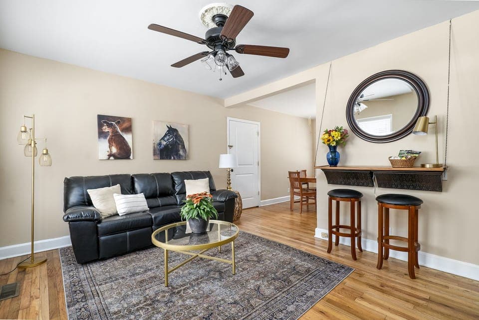 The living room is full of light and features a Roku TV and electric fireplace.