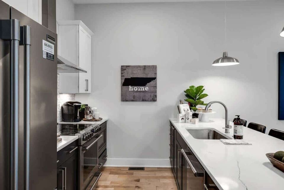 Kitchen with sleek brown cabinets and crisp white counters.