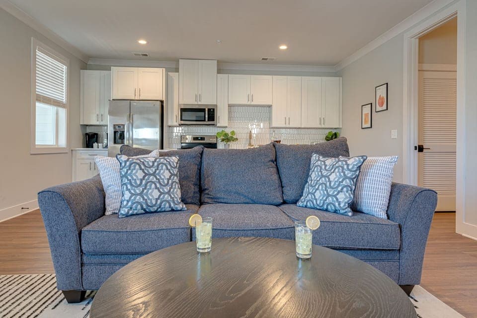 1st Unit: Modern Living Space featuring designer furnishings and a flat-screen SMART TV overlooking the fully equipped kitchen.