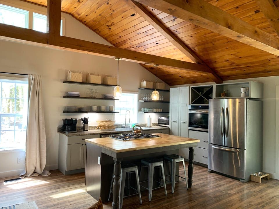 Modern kitchen with vaulted wooden ceiling and island seating, perfect for cooking and socializing.