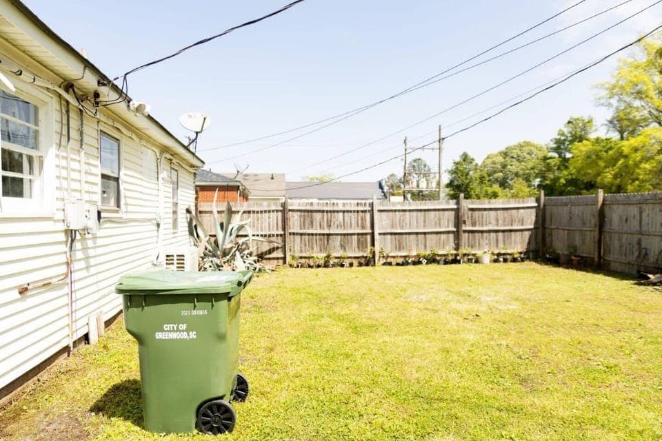 Back yard, partially fenced.  Well lit.  Now has 2 chairs and outdoor table.