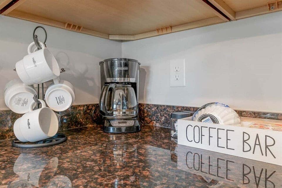 Start your mornings right at the dedicated coffee station, complete with a drip coffee maker and a decorative "Coffee Bar" organizer.