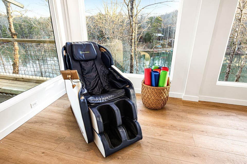 Luxury meets relaxation in this serene space featuring a high-end massage chair overlooking a tranquil, leafy backdrop.