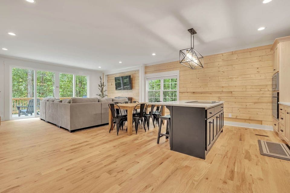 Beautiful gourmet kitchen and living room featuring wood views. 