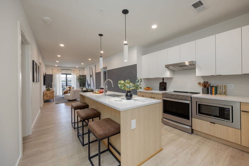 Kitchen stocked with all culinary essentials and fully equipped with brand-new stainless-steel appliances. Features an island with bar seating.