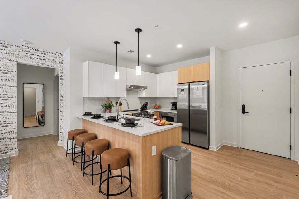 Fully equipped modern kitchen stocked with all culinary essentials and featuring stainless steel appliances with island bar seating.