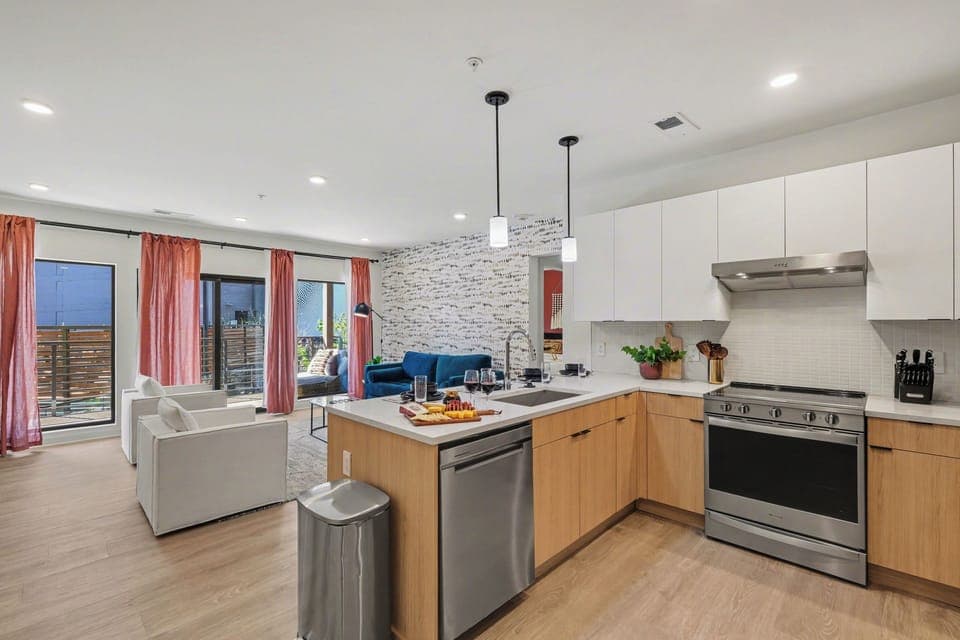 Fully equipped modern kitchen stocked with all culinary essentials and featuring stainless steel appliances with island bar seating.