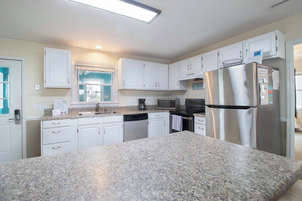 Your spacious kitchen features granite countertops, stainless steel appliances, and bright natural light from the skylight above for delightful cooking.
