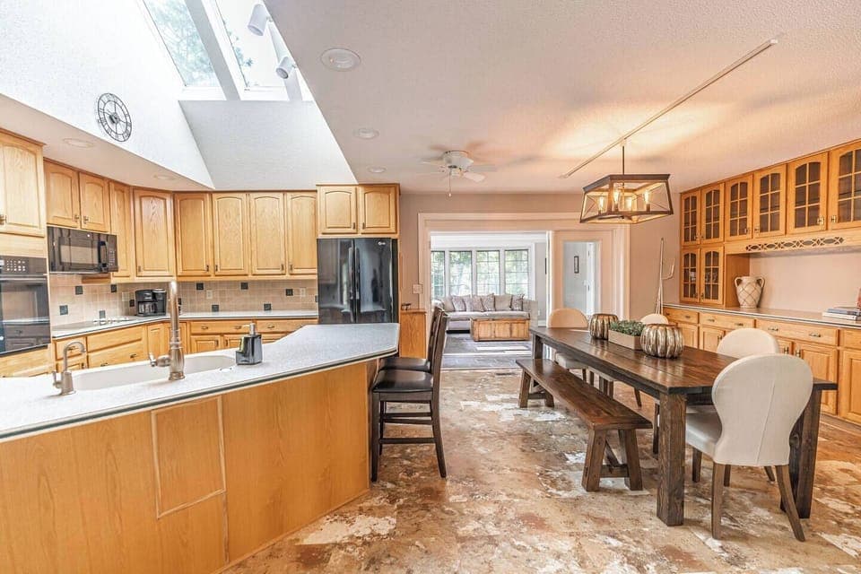Open-concept kitchen and dining area with a bright Carolina room leading to the outdoor deck. Ideal for post-round meals and relaxing or grilling out.