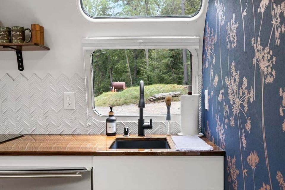 Kitchen essentials provided like dish soap, hand soap, paper towels, and plastic food storage bags. 