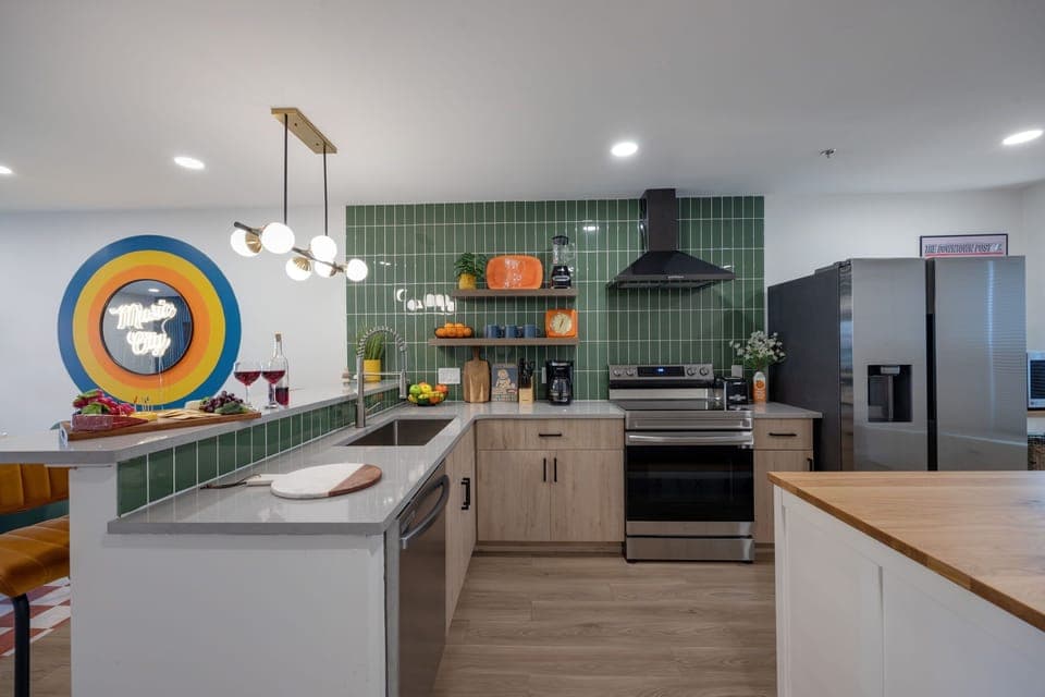 (1st Floor) Fully equipped kitchen with stainless steel appliances, basic cooking essentials, and kitchen island seating.