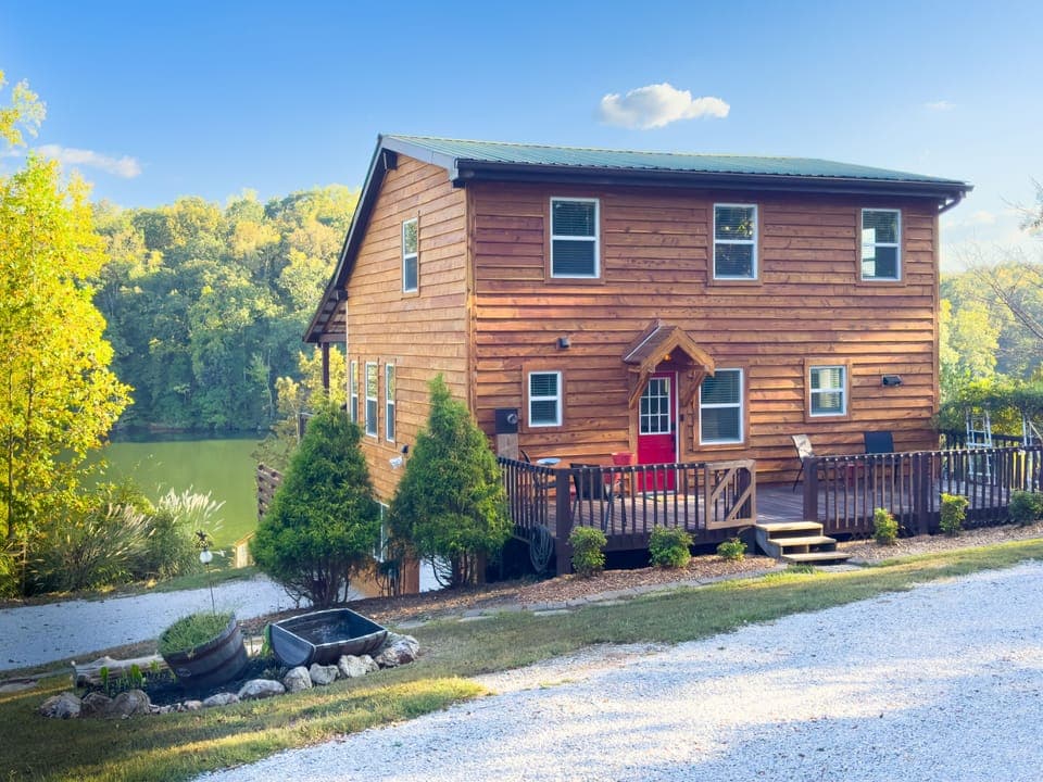 The front of the cabin features a small deck with a few chairs.