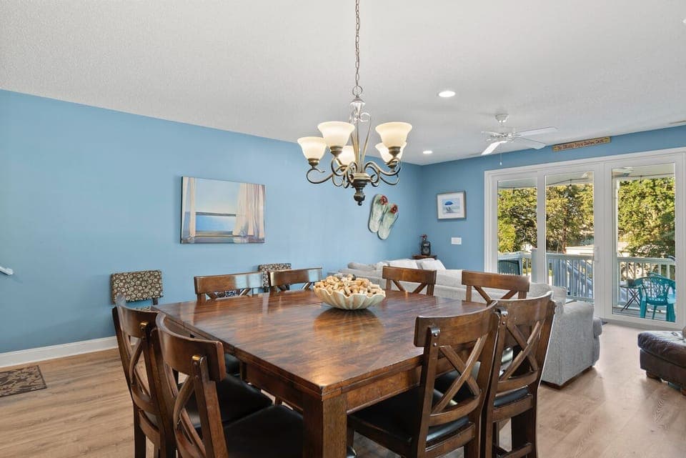 Gather around your spacious dining table where coastal blue walls and warm wood create the perfect backdrop for memorable meals together.